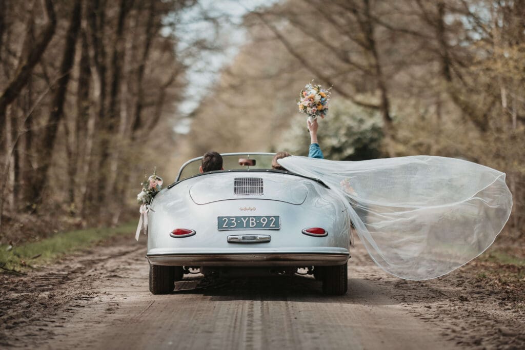 een bruidspaar in een trouwauto